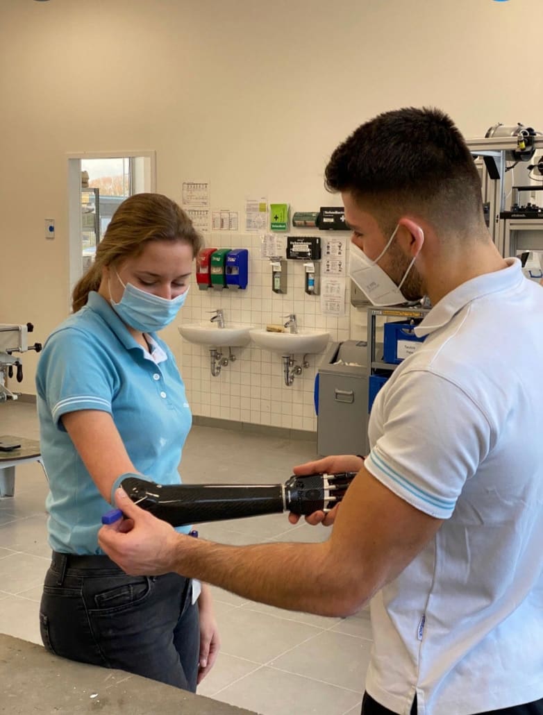 Ioannis Hlamidis adjusting a myoelectric bionic hand for a woman who uses an upper-limb prosthesis