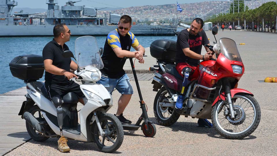 Three men with prosthetic legs on motorbikes on the Thessaloniki seafront, prosthetic limbs in everyday life