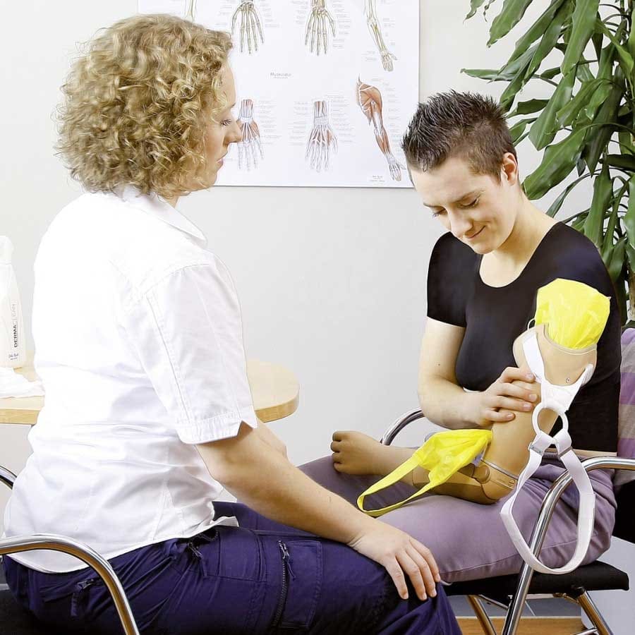 Prosthetist training a user in fitting an above-elbow prosthesis – prosthetic arm