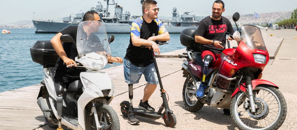 Three prosthetic leg users with scooters on the Thessaloniki seafront – Rheo Knee