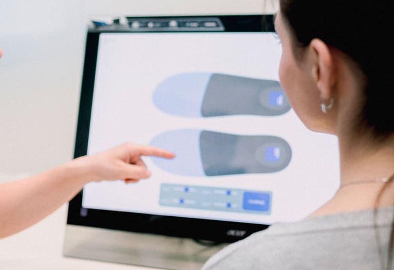 Digital design of 8Sole insoles on a computer screen, together with the customer