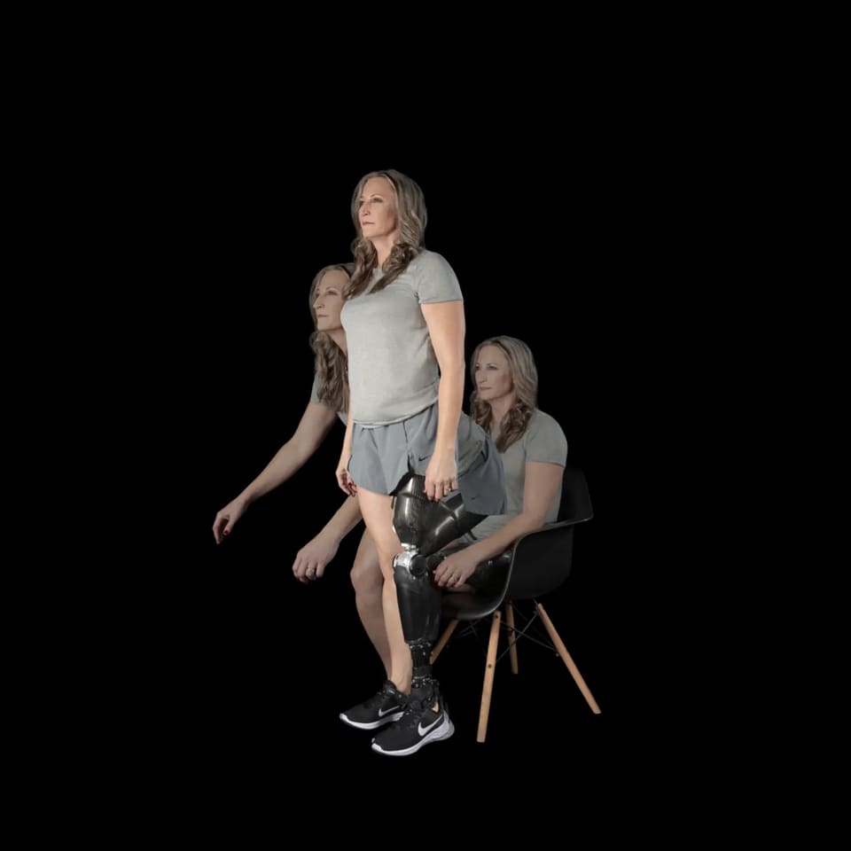Woman with an above-knee prosthesis and Össur Power Knee rising from a chair and walking